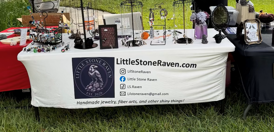 A table of jewelry displays sitting in grass. 